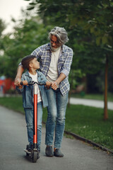 Grandfather with grandchild walking in a summer park