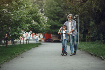 Grandfather with grandchild walking in a summer park