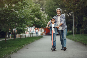 Grandfather with grandchild walking in a summer park