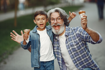 Grandfather with grandchild walking in a summer park