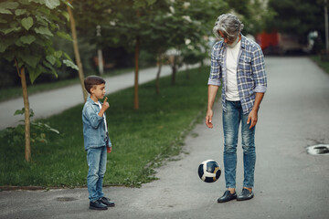 Grandfather with grandchild walking in a summer park