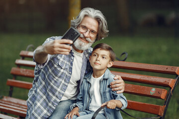 Grandfather with grandchild sitting in a summer park