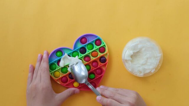 Use the popular pop it toy as a chocolate mold. White chocolate and colorful candies. DIY concept. Step-by-step photo instructions. Step 2. 