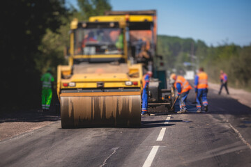Process of asphalting and paving, asphalt paver machine and steam road roller during road...