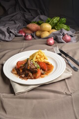 stewed beef steak in marinated sauce with French fries and vegetables Peruvian cuisine menu