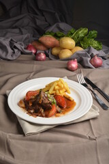 stewed beef steak in marinated sauce with French fries and vegetables Peruvian cuisine menu