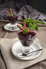 chilled raspberry jelly pudding dessert in glass with cinnamon stick and mint leaf Peruvian cuisine menu
