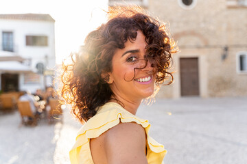Horizontal portrait of curly spanish woman sightseeing in Andalucia. Travel and holidays concept.