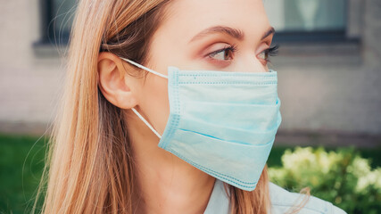 close up of young student in medical mask looking away