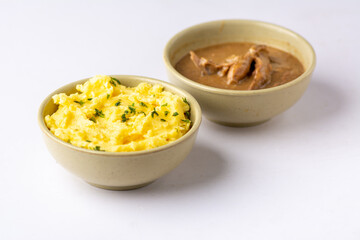 Mashed potatoes with herbs served with chicken sauce on a white background