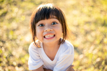 Happy Little asian girl child showing front teeth with big smile and laughing: Healthy happy funny smiling face young adorable lovely female kid.Joyful portrait of asian elementary school student.