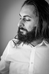 black and white profile portrait of a young middle eastern businessman with beard and long hair © sebastianosecondi