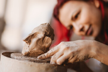 Young woman sculptor artist creating a bust sculpture