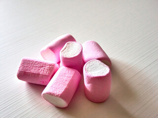 Heap of marshmallows isolated on a white background on a wooden table