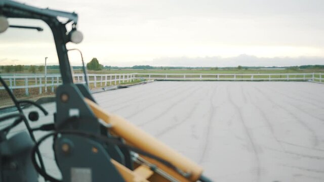 A farm Utility Vehicle (UTV) close-up view. Yellow utility vehicle in the horse ranch with wooden fences to carry out specific tasks. Slow-motion daytime footage.