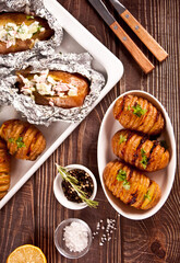 American traditional homemade Hasselback Potato and stuffed potatoes with fresh herbs and bacon.