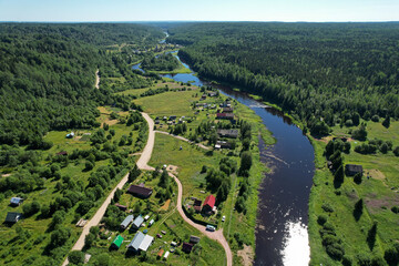 Fototapeta na wymiar aerial view river flowing village by the river in the middle of the forest river bend houses and agricultural field