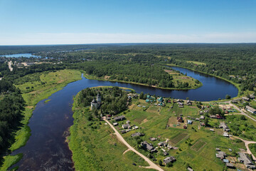 Fototapeta na wymiar aerial view the river flows the village on the bank of the river in the middle of the forest the bend of the river church on the bank of the river flowing into another