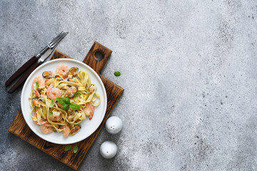 Tagliatelle pasta with seafood and parmesan in a plate. View from above. Pasta with shrimps and mussels.
