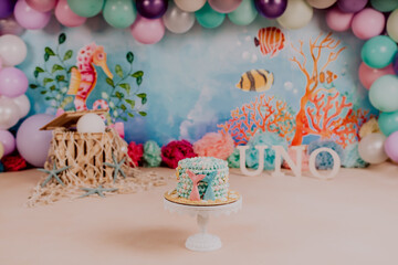 Obraz premium First birthday smashcake photo session of an under the sea and little mermaid theme in a photo studio