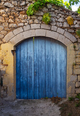 Fototapeta na wymiar Wooden blue gate at the entrance to the courtyard of a Greek house in the city of Arachova in Greece