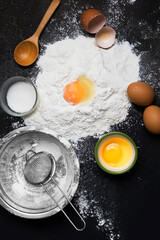 Ingredients for baking - flour sugar and eggs on dark background - Top view with copy space