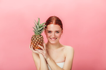 Front view of pleasant girl with exotic fruit. Studio shot of ginger young woman with pineapple...