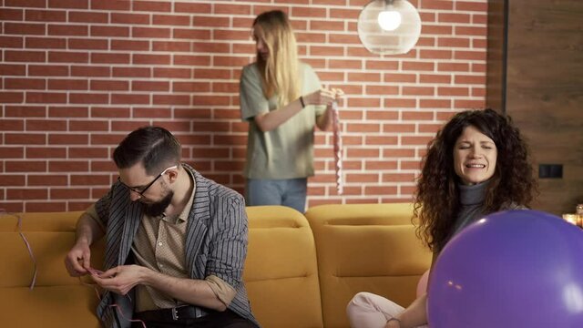Positive Caucasian men and women having fun preparing partying indoors