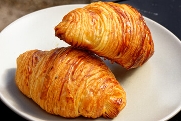 Close-up with fresh golden croissants on a plate