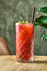 Obraz premium Alcoholic cocktail strawberry mojito with lime and mint in a glass with ice