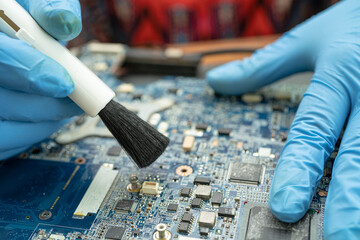 Technician use brush and air blower ball to clean dust in circuit board computer. Repair upgrade...