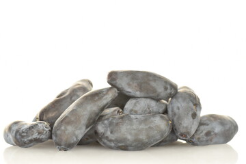 Several dark blue organic ripe honeysuckle berries, close-up, isolated on white.