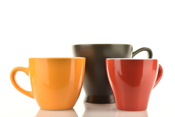 Three ceramic cups, close-up, isolated on white.