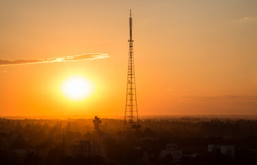 Fototapeta premium Stunning sunset in the city with the silhouette of a radio tower