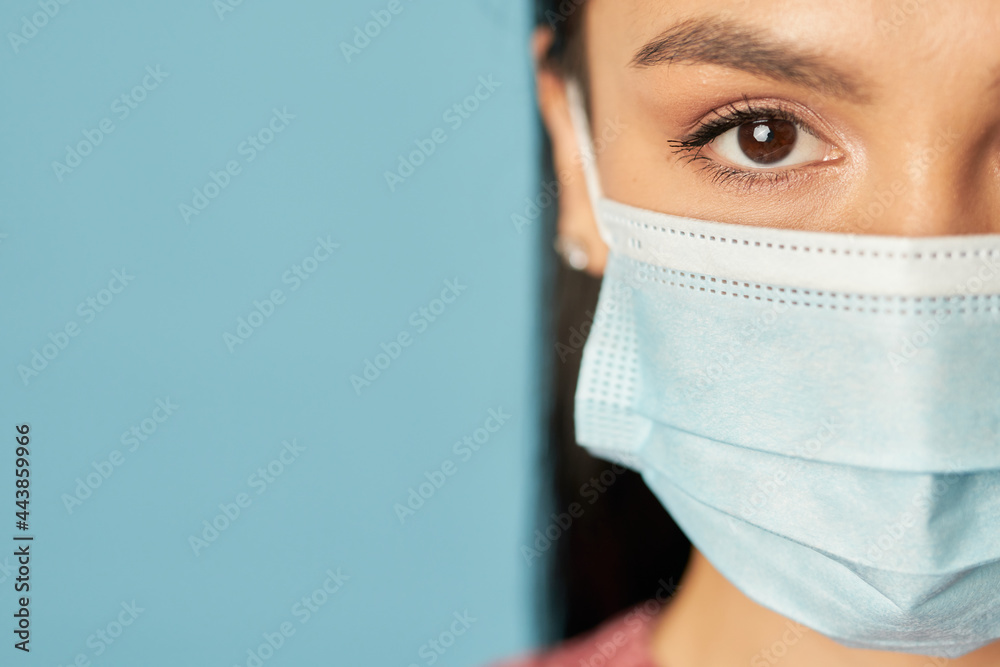 Wall mural young lady in blue medical mask posing in studio