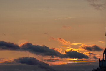 Sunset sky with sun behind gray clouds and architecture detail piece. Background image with copy space for text.