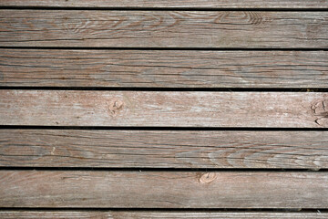 Fototapeta na wymiar The texture of natural materials. Boardwalk pier on the river bank in the rain and sun