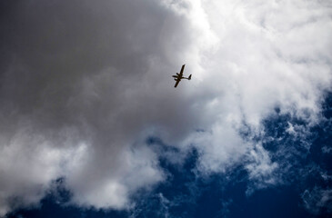 A small plane flying over a cloudy sky