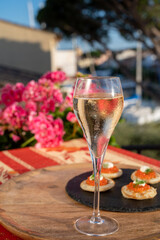 Drinking of white cold champagne, bliny with red caviar and view on Port Grimaud near Saint-Tropez in summer