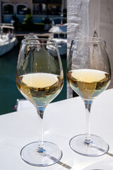 Summer on French Riviera Cote d'Azur, drinking cold dry white wine from Cotes de Provence on outdoor terrase in Port Grimaud, Var, France