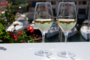 Summer on French Riviera Cote d'Azur, drinking cold dry white wine from Cotes de Provence on outdoor terrase in Port Grimaud, Var, France