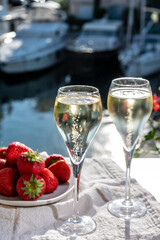 Summer party, drinking of French champagne sparkling wine in glasses in yacht harbour of Port Grimaud near Saint-Tropez, French Riviera vacation, France