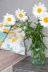 Daisies in vase on bedside table