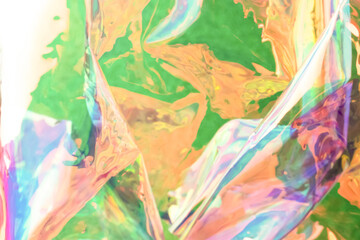 Blurred holographic background. Defocused multicolored texture of wrinkled foil.