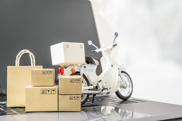 Fast parcel delivery, e-commerce service concept : Motorbike, shopping bag, boxes on a laptop,...
