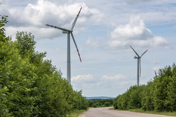 rotating blades of a windmill propeller on blue sky background. Wind power generation. Pure green...