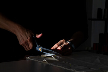 Hands cutting fabric with scissors