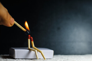 Two matches burning sitting together on the matchbox in the dark copy space. Two matches in flame...