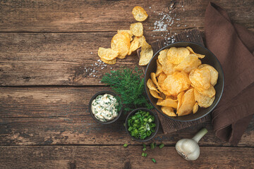 Chips with dill, sour cream and garlic on a wooden background. Appetizer for beer.