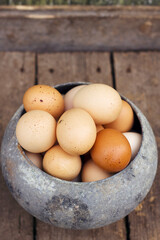 Fresh farm eggs in old vintage pot  with vertical photo. Healthy and natural food concept. Organic egg for cooking on the wooden table.